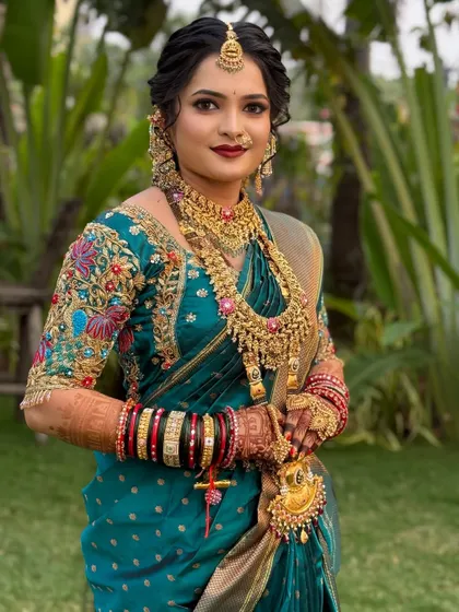 A beautiful bride in a teal Nauvari saree, with intricate gold jewellery and a soft, elegant makeup look.