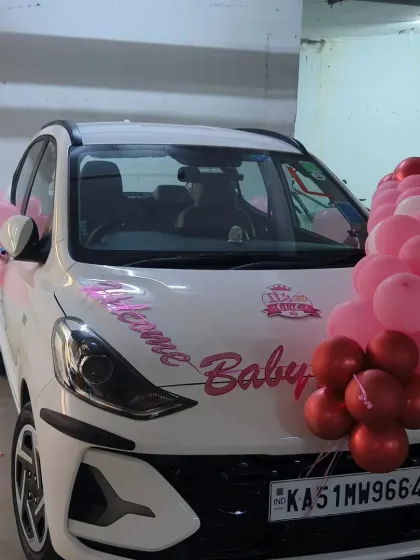 Another angle of the car decoration for a baby girl's arrival, showing the balloon arrangements on the hood and side mirrors, ready for the drive home from the hospital.