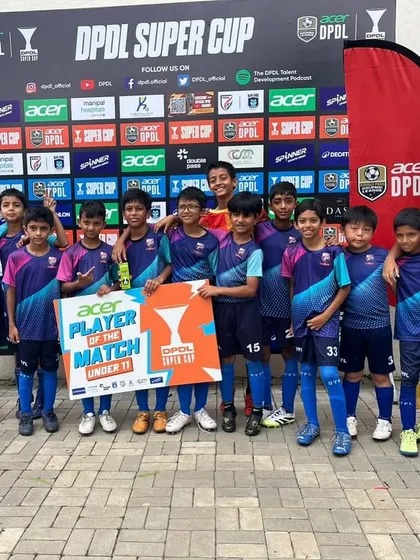 The U11 team celebrating their Player of the Match, Ashwadh.