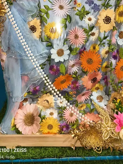 For this beautiful floral embroidered suit, I used golden decorative elements and a pearl string to add a touch of luxury. The packing is designed to showcase the colorful and intricate thread work of the outfit.