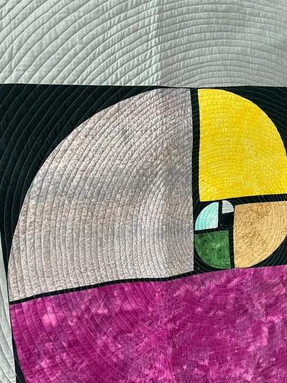A detail shot of the Fibonacci spiral quilt, showing the precision of the spiral quilting.