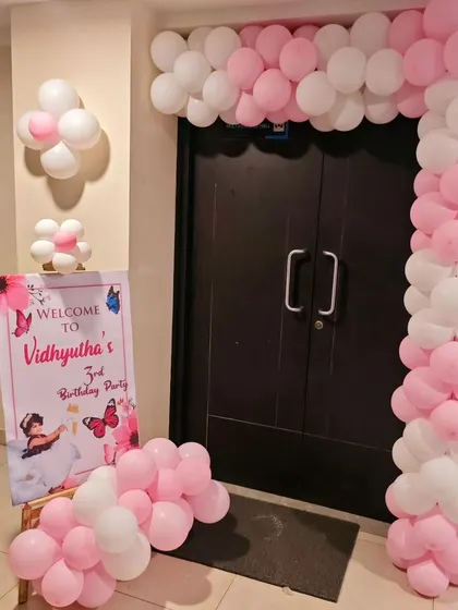 A simple and sweet pink and white balloon arch and welcome sign for Vidhyutha's party.
