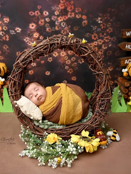 As sweet as honey. This newborn is dressed as a tiny bee, sleeping in a hive-like nest surrounded by sunflowers. It is a wonderfully sweet and charming theme.