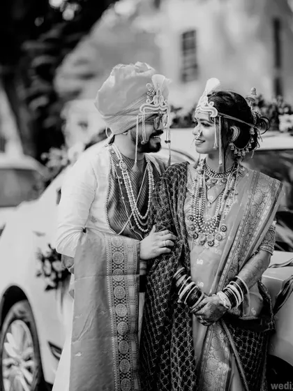 A timeless black and white photo of a couple after their wedding ceremony, standing by their decorated car. This style adds a touch of classic elegance.