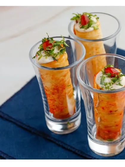 A fusion appetiser with a spicy kick. These crispy rolls are filled with peri peri seasoned cream cheese and served in shot glasses for a modern and convenient presentation.