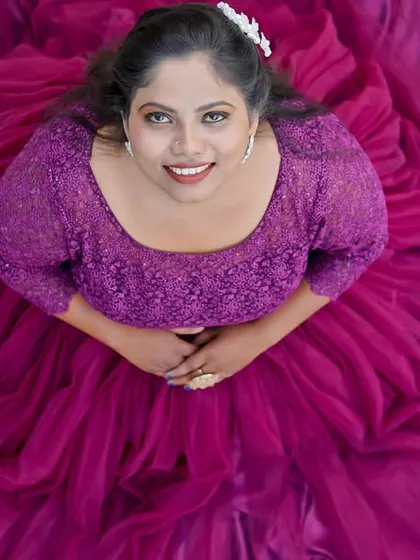 A beautiful high-angle portrait of a woman in a flowing purple gown. This style of photography can be used for maternity sessions to create elegant and artistic images.