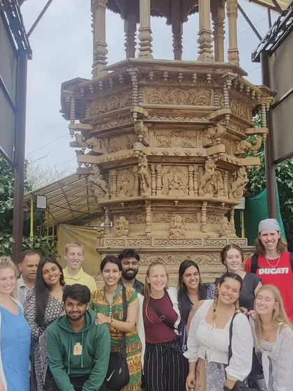 Visiting students and faculty pose in front of the stone chariot replica at our Mandala Cultural Centre. The centre itself is a place of learning, filled with art and architectural elements.