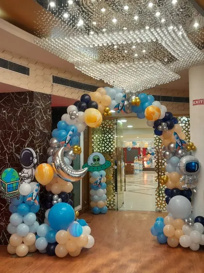 The entrance to the space party. This balloon arch is decorated with astronaut, moon, and planet foil balloons to create an immersive experience from the moment guests arrive.