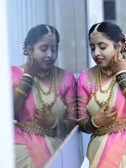 A moment of reflection for this beautiful bride. Her makeup is soft and romantic, with pink tones on her cheeks and lips to match her lovely pink and cream silk saree.