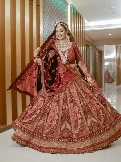 A full-length shot of the bride twirling in her magnificent velvet lehenga. A perfect shot to showcase the grandeur of the outfit.
