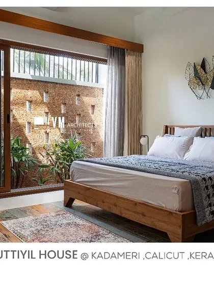 A duplicate of image 99, showing the beautifully designed bedroom in Kuttiyil House with its wooden furniture and connection to the outdoors.