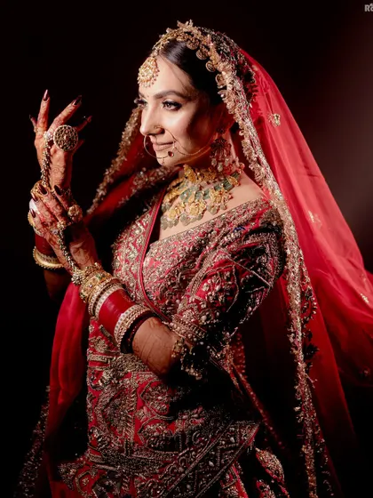 I believe a bridal portrait should be more than just a photo; it should be a reflection of her soul. Using dramatic lighting, I focused on this bride's serene expression and the intricate details of her red lehenga and jewelry, creating a powerful and timeless image.