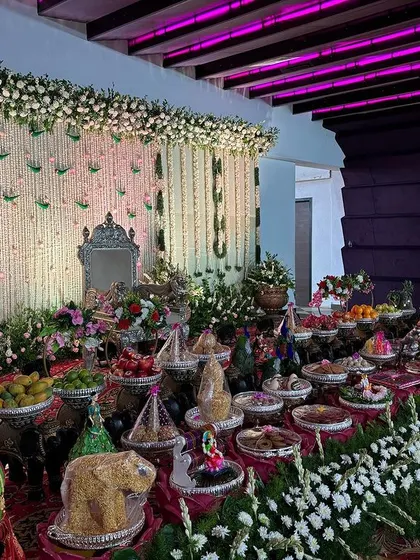 A side view of the white floral stage and its extensive offering table.