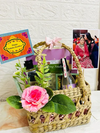 The complete Rakhi hamper for a sister, beautifully arranged in a mesh jute basket with a personal photo and festive card.