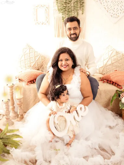 A beautiful family portrait in all-white, celebrating their daughter's first birthday with elegance and grace.