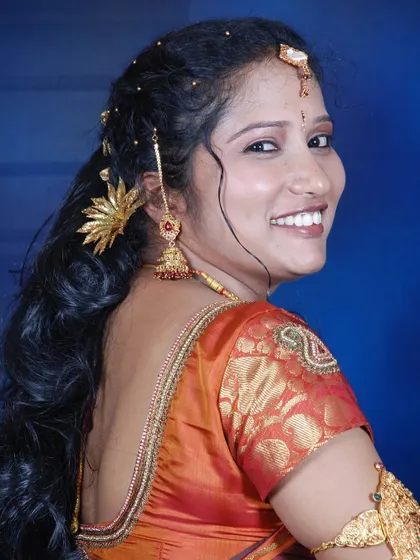 A happy bride looking over her shoulder, showing off her beautiful hairstyle and smile.