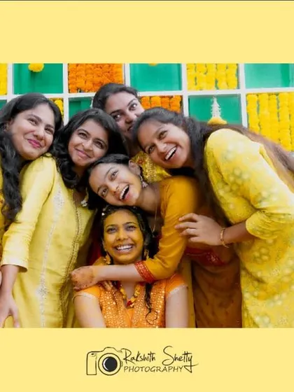 A heartwarming photo of the bride surrounded by her friends and family in a group hug. This image perfectly captures the love and support that makes a Haldi ceremony so special.