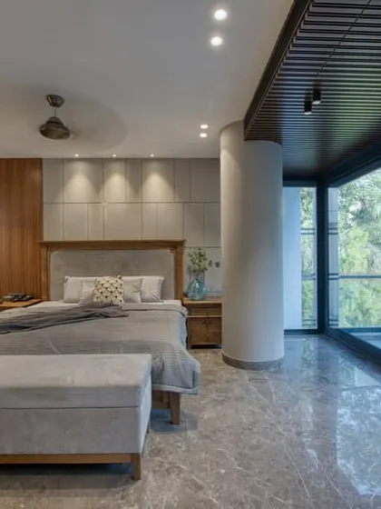 A spacious and airy bedroom with a large balcony. The design uses a mix of wood, soft textiles, and a neutral color palette to create a connection with the outdoors.