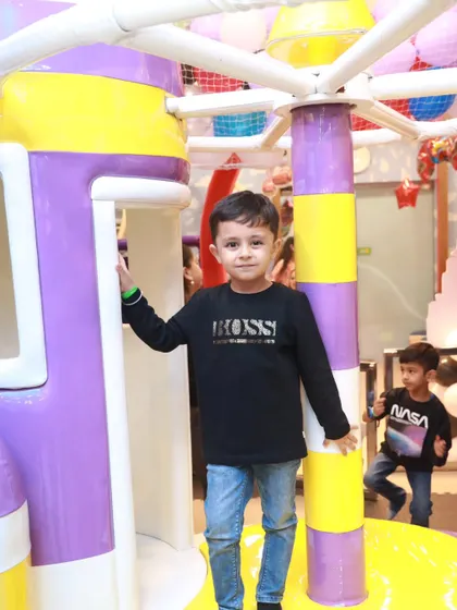 A young guest posing by our space-themed play structure. Our play area is a popular choice for birthday parties and group playdates.