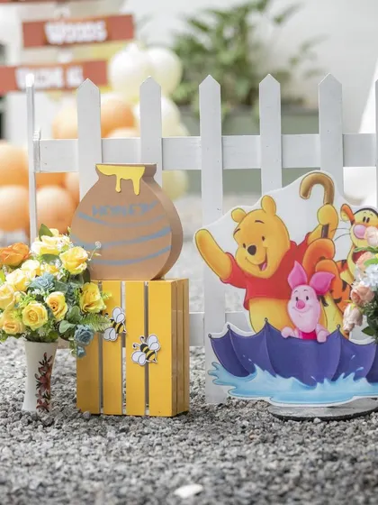More props from the Hundred Acre Wood. This cutout features Pooh, Piglet, and Tigger under an umbrella, adding a playful touch to the entrance decor.