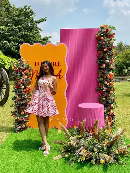 The gorgeous bride-to-be posing in front of the vibrant decor we created for her. The bright pink and orange colors perfectly matched her fun and cheerful personality.