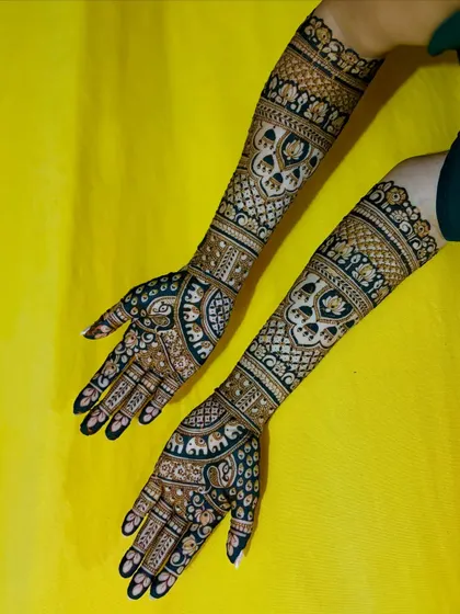 A beautiful bridal mehendi with a dark stain, featuring elephant motifs and intricate patterns against a vibrant yellow background.