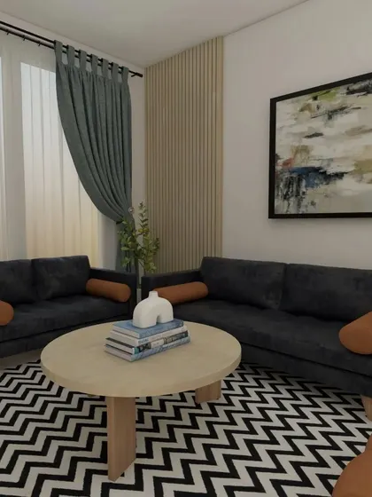 A Scandinavian-inspired living room with a dark grey sofa, a bold chevron rug, and a pop of color from the tan armchair. The wood-paneled accent wall adds warmth and texture.