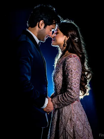 A dramatic, backlit portrait taken during a Sangeet night. This creative lighting technique creates a stunning silhouette and a truly cinematic feel.