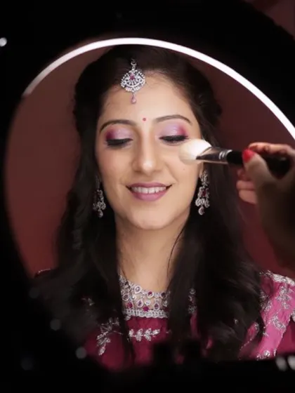 Applying a touch of powder through a ring light. This behind-the-scenes shot shows how I set the makeup to ensure it stays flawless all day and night.