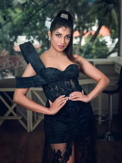A full-length shot of actress Iti Acharya in an elegant black gown. This photo highlights the dress's unique design and is suitable for fashion features or red carpet-style portfolios.