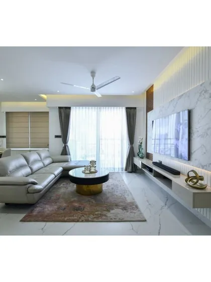 A refined and elegant living room from the Diamond District project, where the TV unit is integrated into a larger design of fluted panels and marble flooring.