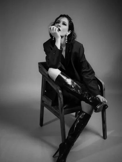 The black and white version of a shot from the 'FLOR' series. This treatment emphasizes the shapes, shadows, and textures of the blazer and boots.