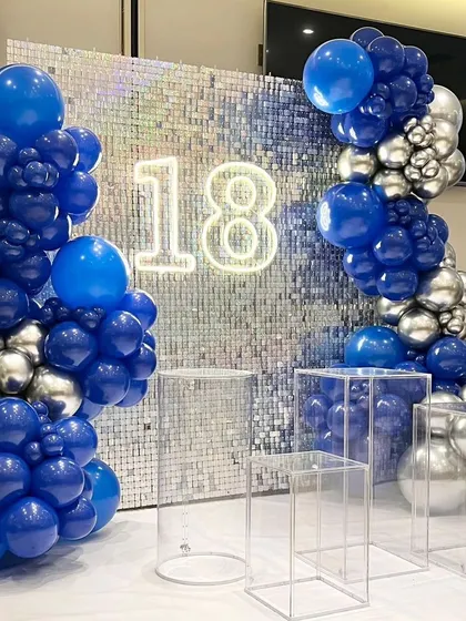 Another view of the 18th birthday sequin backdrop, showcasing the clear acrylic plinths that add a modern touch and can be used for displaying a cake or gifts.