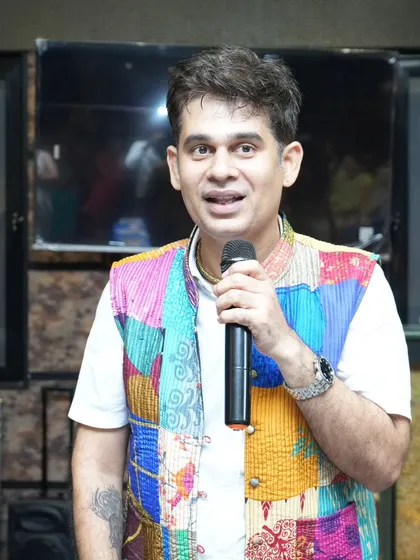 A close-up of me on the mic, wearing a festive jacket for a traditional event. I always dress for the occasion!
