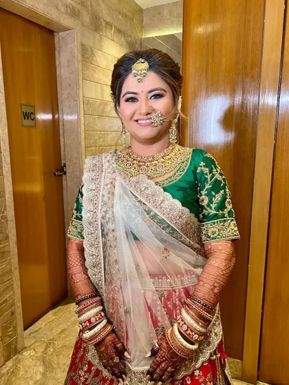 A full-shot of the bride, looking radiant and ready. The makeup is balanced to complement her colorful and traditional attire.