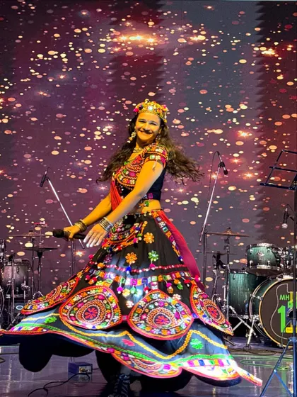 On stage, I come alive. This shot from a Navratri event captures the dynamic movement and vibrant energy I bring, modeling a stunning traditional ghagra choli.