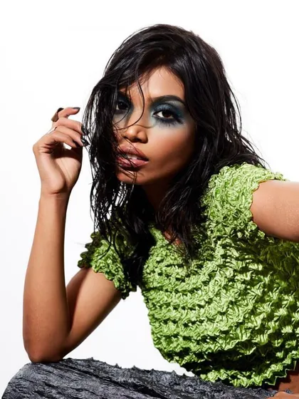 A portrait featuring a dark, smudged smokey eye and a textured wet-look hairstyle, creating a grungy yet chic aesthetic.