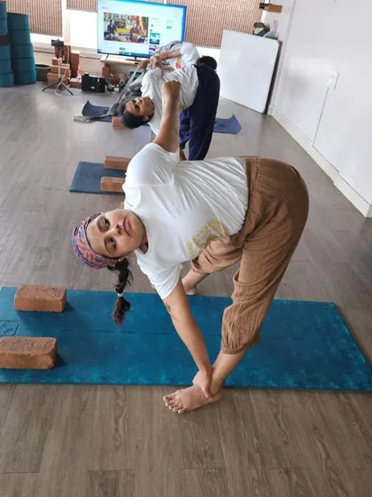 The joy of progress is evident in this student's smile as she practices a twisting pose. Our TTC is not just about learning; it's about finding happiness in the journey.