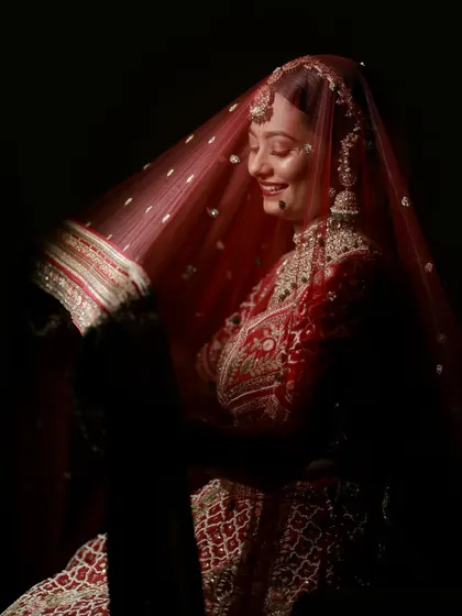 A candid moment of joy. Krupa's smile shines through her veil, showcasing how a well-executed makeup look can make a bride feel confident and happy.