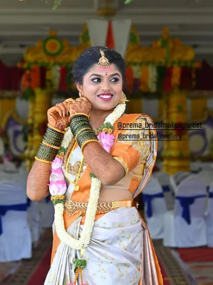 The bride adjusting her jhumkas, giving a great view of the complete set and her flower garland.