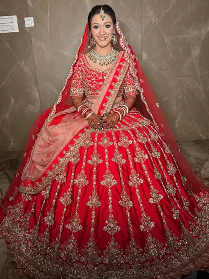 A full-length shot of the bride, looking regal and elegant in her red lehenga.