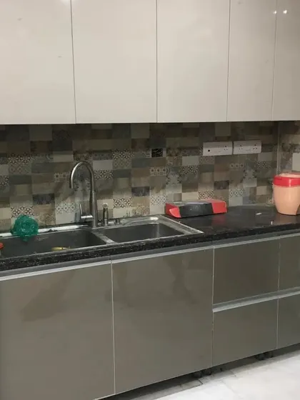 A shot of the sink area in the delivered two-tone kitchen. The seamless countertop and deep sink add to the functionality of this well-designed modular kitchen.