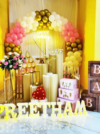A lovely and affordable birthday setup featuring a balloon arch, 'BABY' blocks, and light-up letters. We can customize the colors to match your preference.