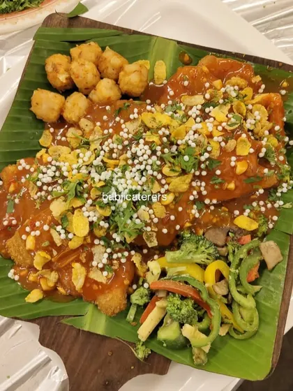 Our Chicken Crackers, served with butter-tossed veggies and fried potato bites. The presentation on a banana leaf adds a traditional touch to this modern dish.