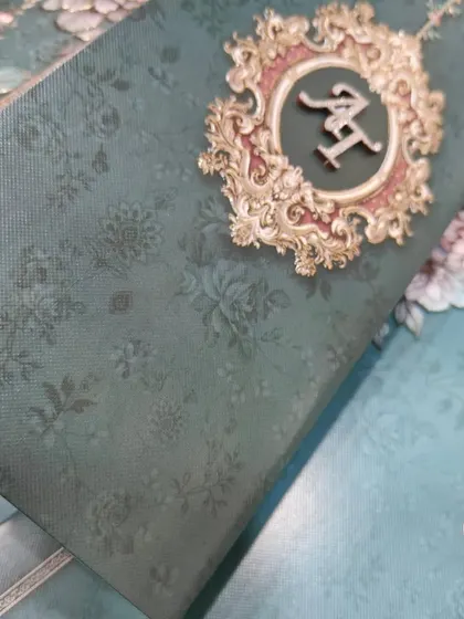 A detailed shot of the glittered MDF initials on the emerald green invitation. This level of personalization, combining different materials and textures, is what makes my bespoke invitations stand out.