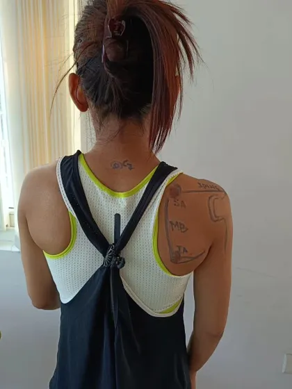 A closer look at the anatomical markings on a student's back. This method helps solidify the understanding of bony landmarks, which is essential for accurate cueing and exercise modification.
