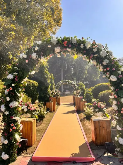 A breathtaking entranceway. We created a pathway of floral arches, using a mix of white and pastel pink flowers, to guide guests into a garden of celebration.