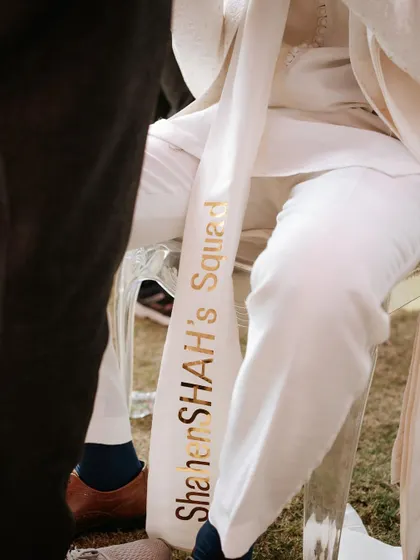 A custom stole for a member of the groom's squad, embroidered with 'ShahenSHAH's Squad'. A fun and personal touch for the wedding party.