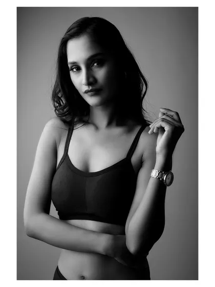 A moody black and white portrait. The lighting creates deep shadows, highlighting the subject's form and creating an image full of emotion and strength.