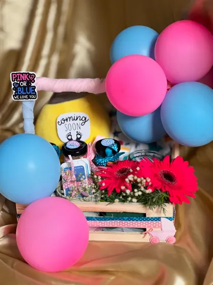 This baby shower gift hamper is ready to go. The combination of bright flowers, balloons, and curated gifts creates a joyful and celebratory present.